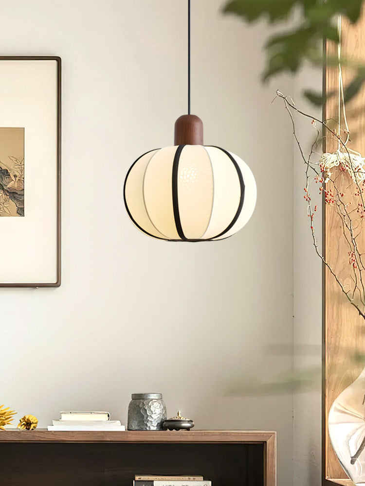 Beside a framed print and bare branch, this Clérachic pendant's cream ribbed shade glows against a plain wall.