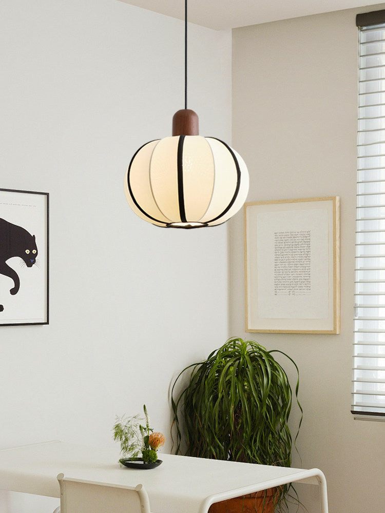 In a corner beside a black-cat print and blinds, this Clérachic pendant glows warm above a small dining table.