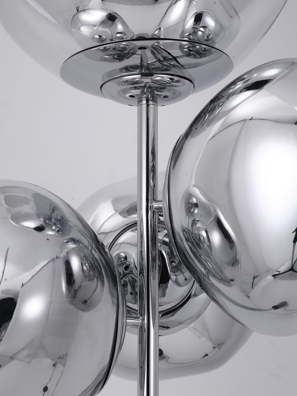 A close-up of the chrome mounting rod and discs joining this Clérachic floor lamp's mirror-chrome globes into their clustered arrangement.