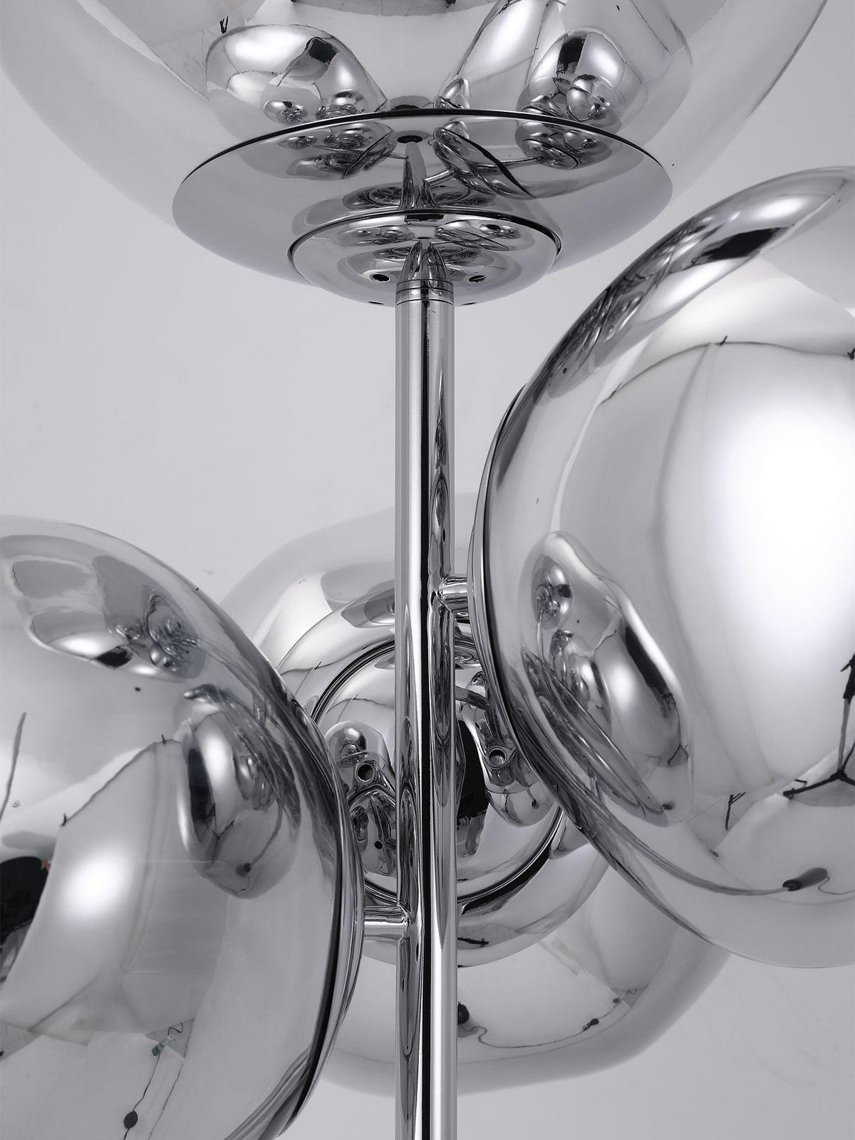 A close-up of the chrome mounting rod and discs joining this Clérachic floor lamp's mirror-chrome globes into their clustered arrangement.