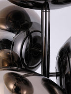 A low-angle close-up of this Clérachic floor lamp's mirror-chrome globes, showing how the chrome rod and discs hold the cluster together.