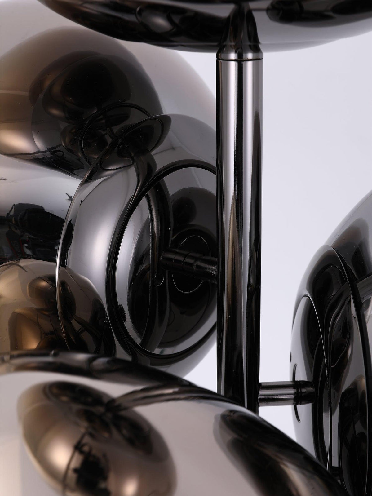 A low-angle close-up of this Clérachic floor lamp's mirror-chrome globes, showing how the chrome rod and discs hold the cluster together.