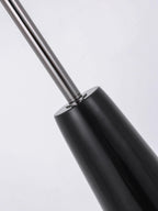Close-up of the chrome rod meeting the glossy black conical base of this Clérachic floor lamp, the join shown against a plain backdrop.