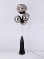 Clérachic floor lamp shown unlit and square-on against a pale backdrop, its mirror-chrome globes and black conical base fully visible.