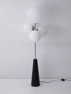 Clérachic floor lamp shown unlit against a plain grey backdrop, its frosted white glass globes and power cord fully visible.
