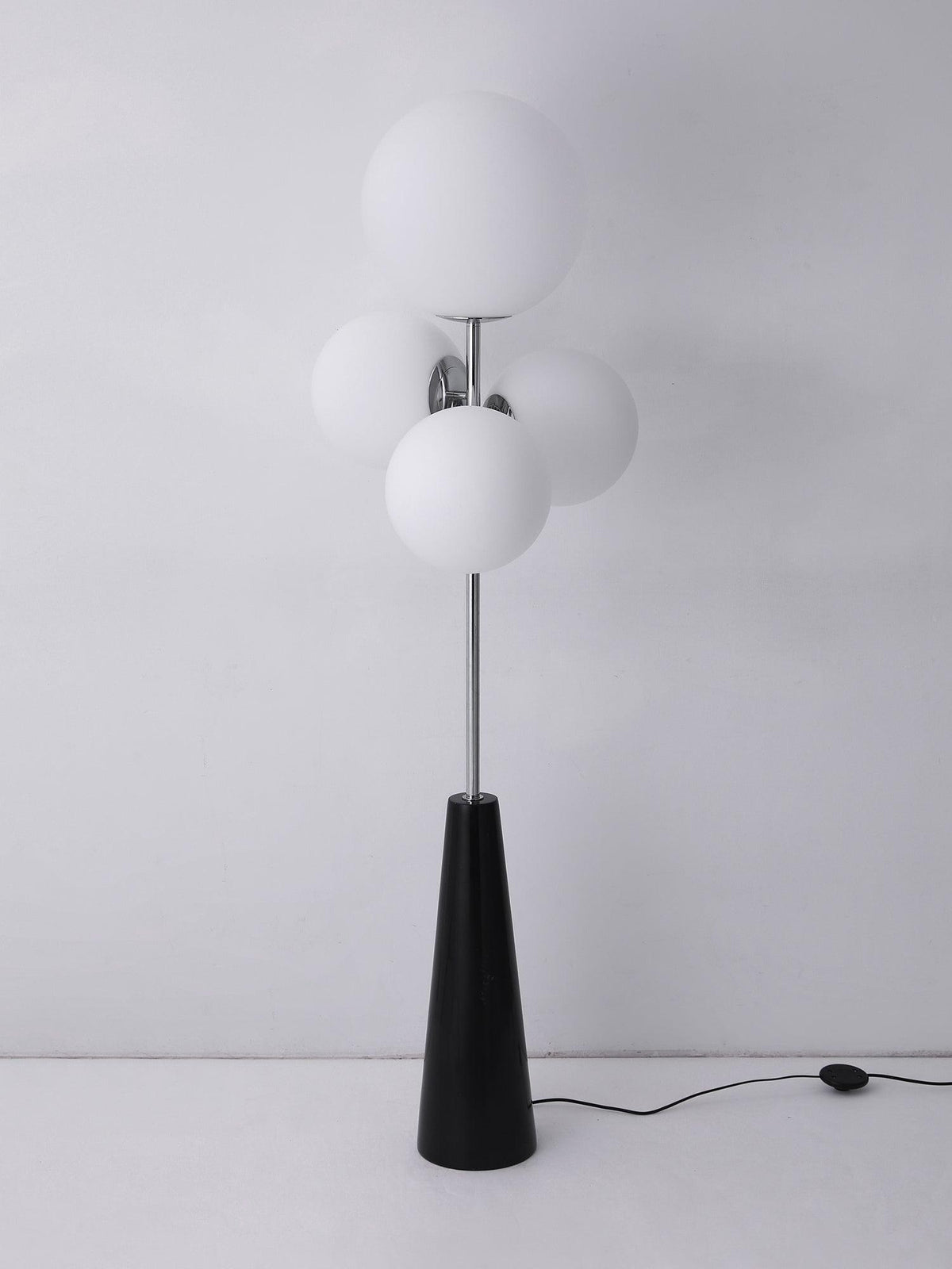 Clérachic floor lamp shown unlit against a plain grey backdrop, its frosted white glass globes and power cord fully visible.