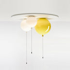 Three balloon-shaped shades in white, cream and yellow share one ceiling plate, this Clérachic light fixture shown together.