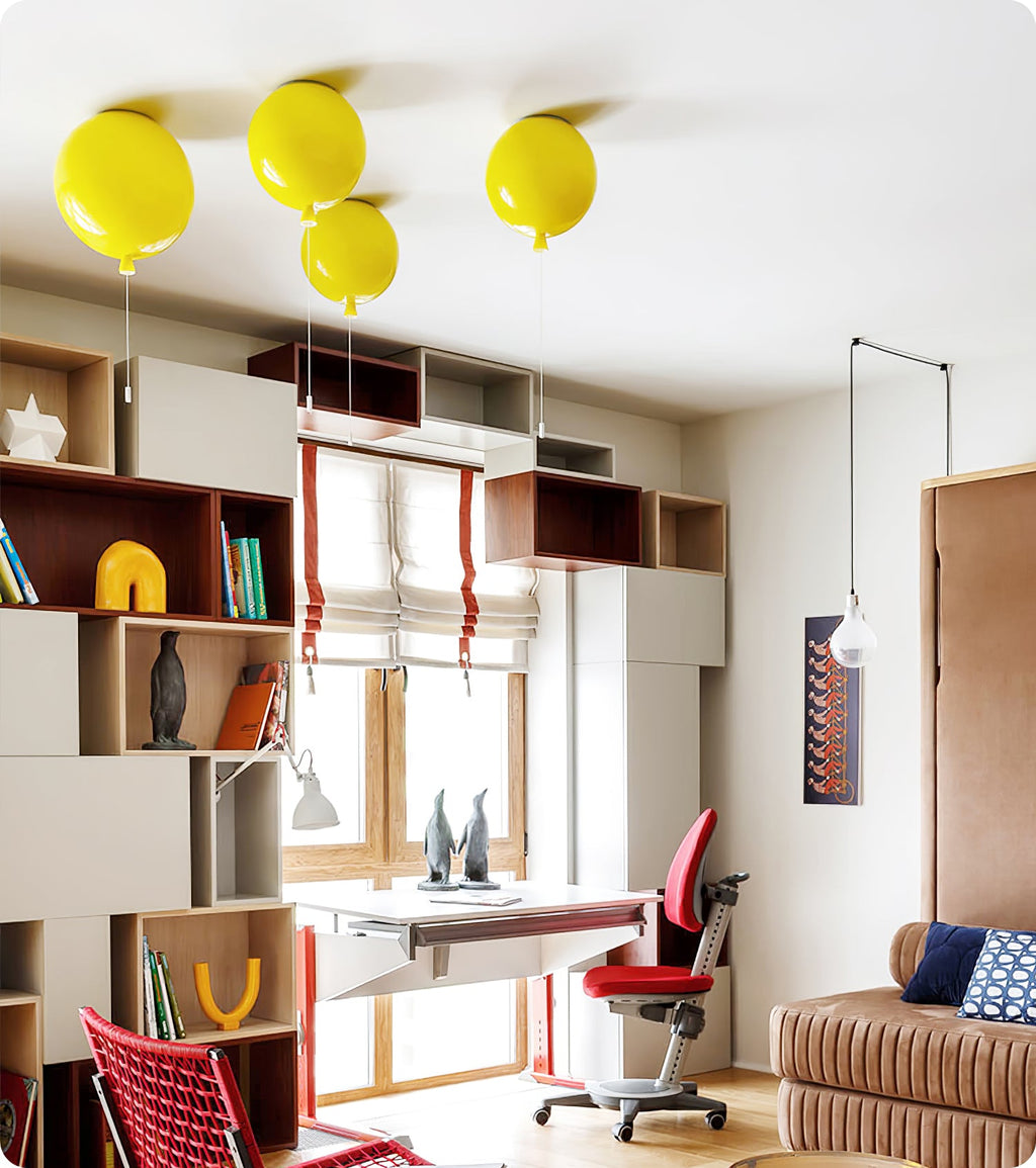 Four yellow balloon ceiling lights from Clérachic cluster on a white ceiling above a child's desk and bookshelf.