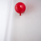 Playful balloon-shaped wall sconce mounted in a room