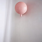 Sculptural balloon wall sconce with a dangling pull cord