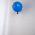 Sculptural balloon wall sconce lit in a child's room