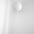 Balloon-shaped wall light glowing softly against a wall