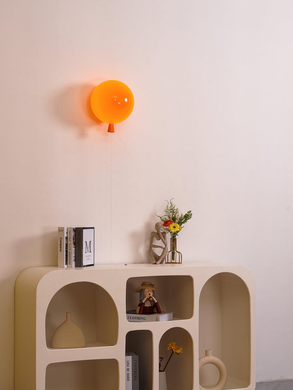 Balloon-shaped wall sconce lit warmly above a table