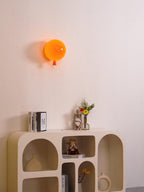 Balloon-shaped wall sconce lit warmly above a table