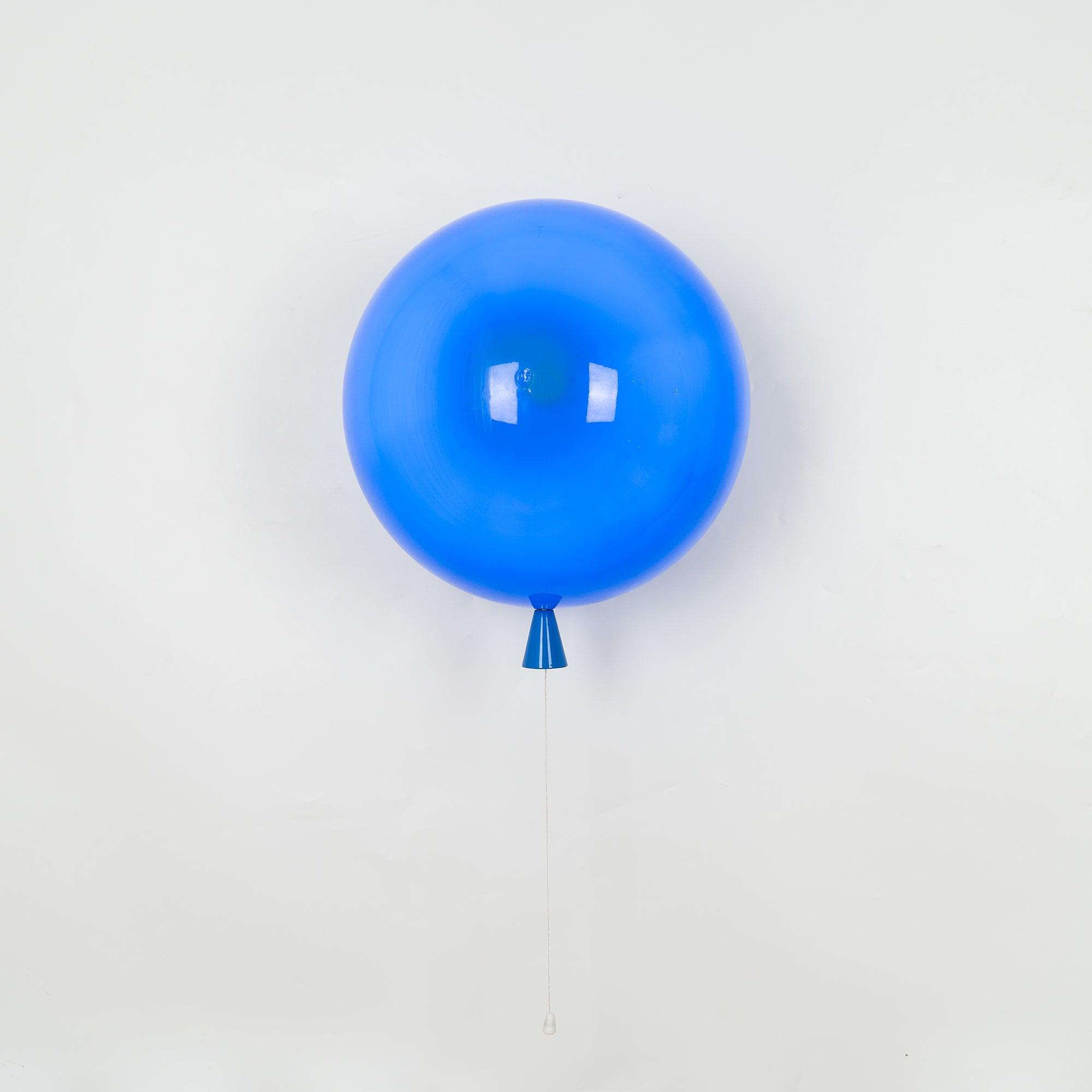 Balloon-shaped wall light with warm glow on a wall