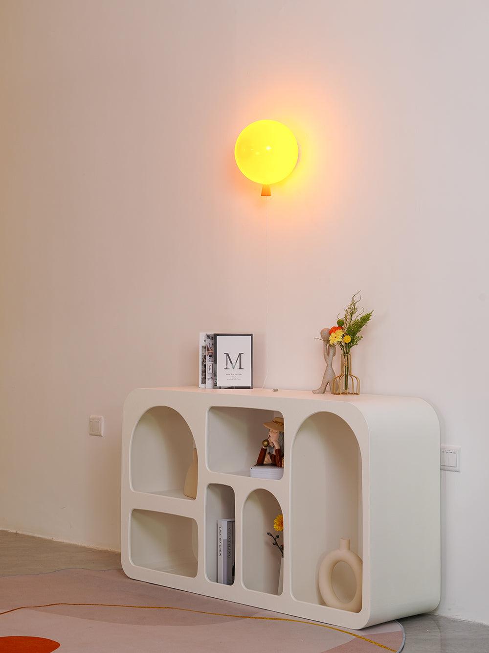 Balloon wall light with rounded shade glowing in a room