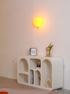 Balloon wall light with rounded shade glowing in a room