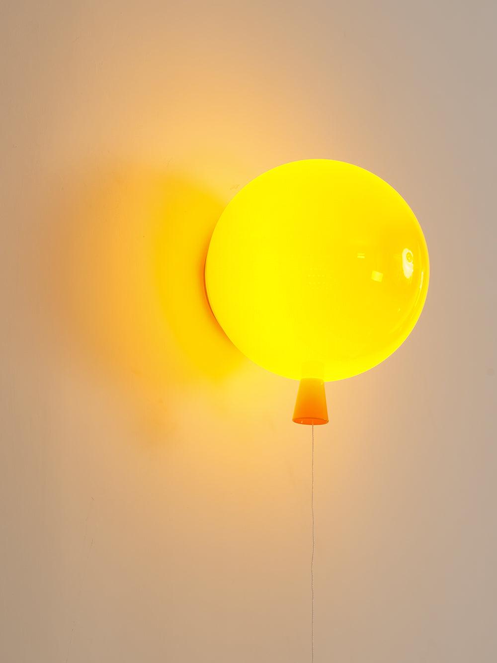 Playful balloon wall sconce with rounded coloured shade lit