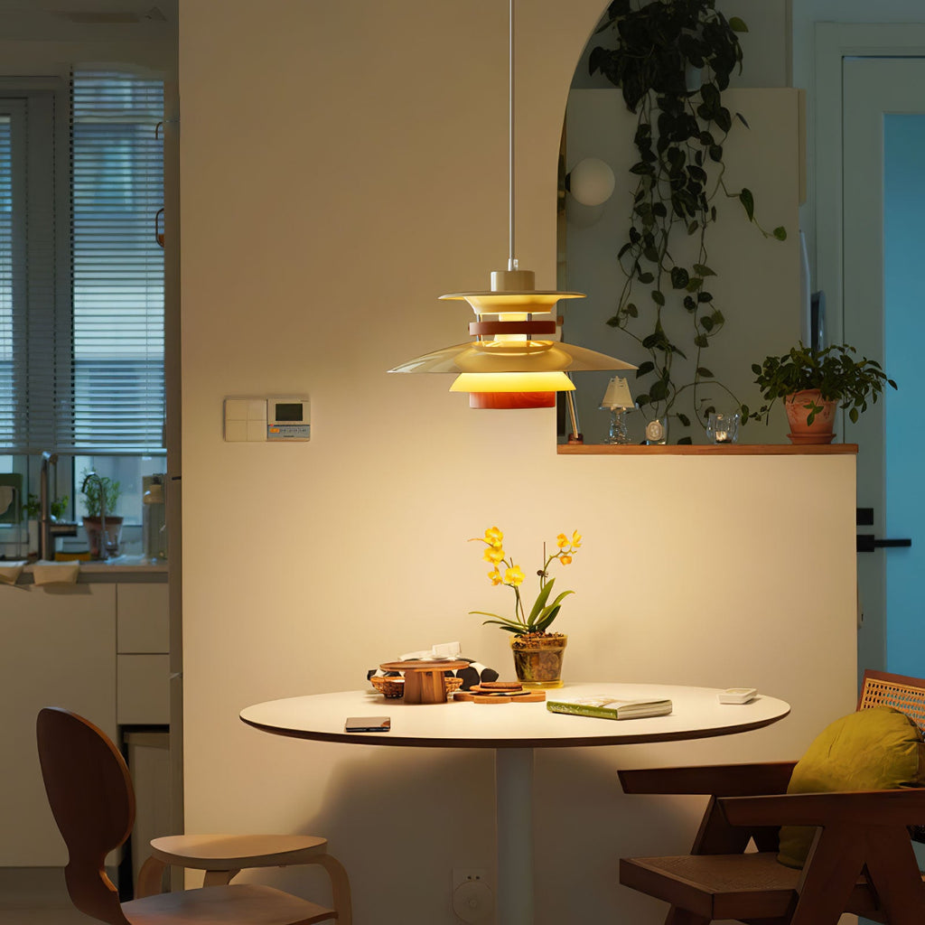 A beige Clérachic pendant lights a round table in a warm kitchen corner with plants.