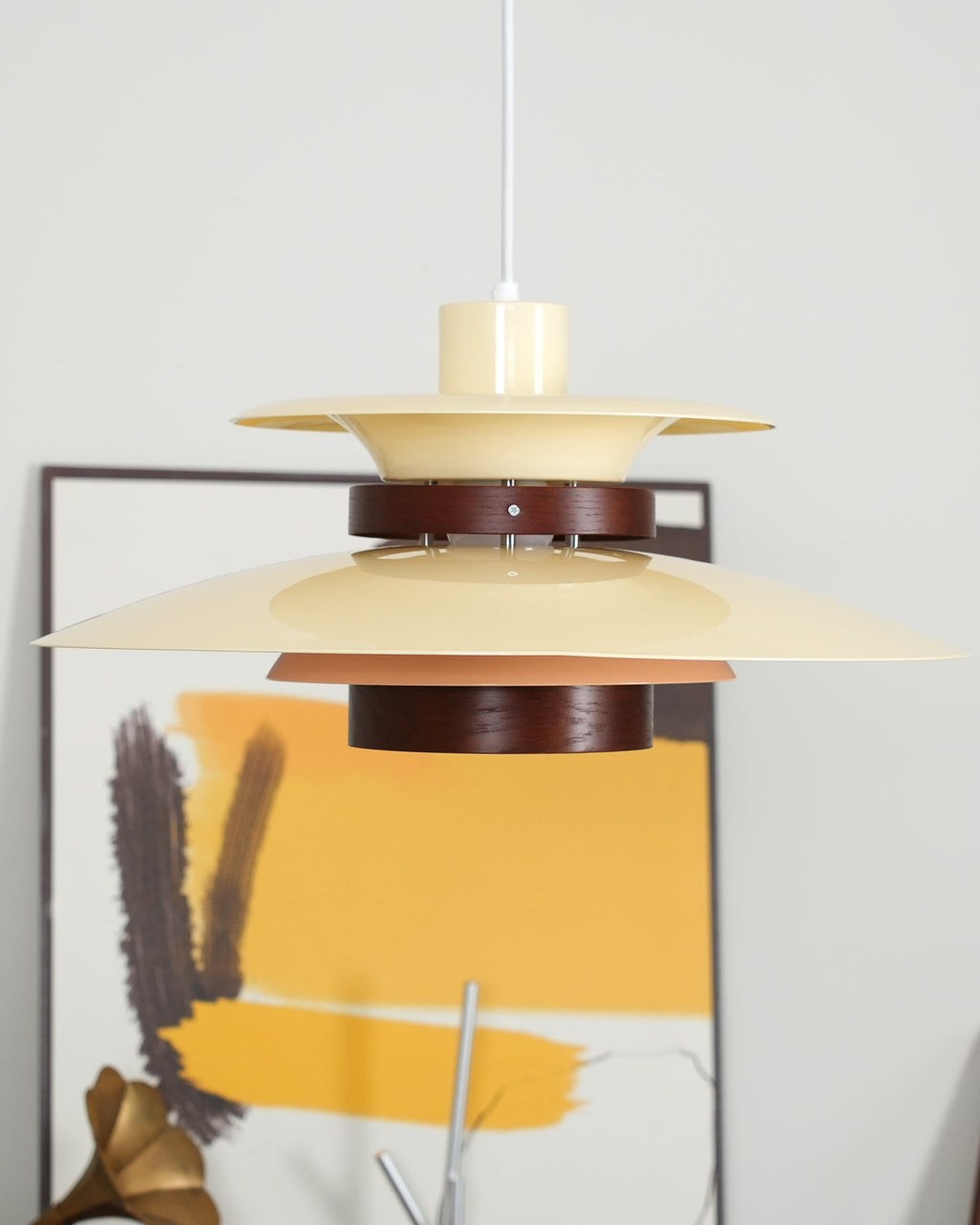 Close view of the beige shades and dark walnut ring on this Clérachic pendant, lit.
