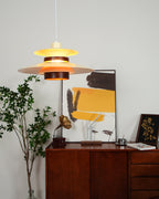 A lit beige Clérachic pendant hangs low beside a sideboard styled with a gramophone and art.