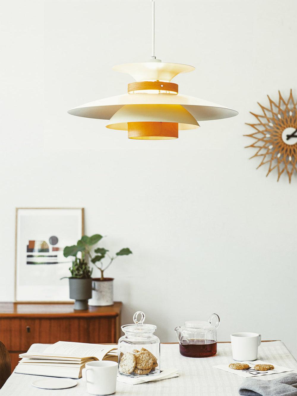 Close view of the beige shades on this Clérachic pendant beside a sunburst wall clock.