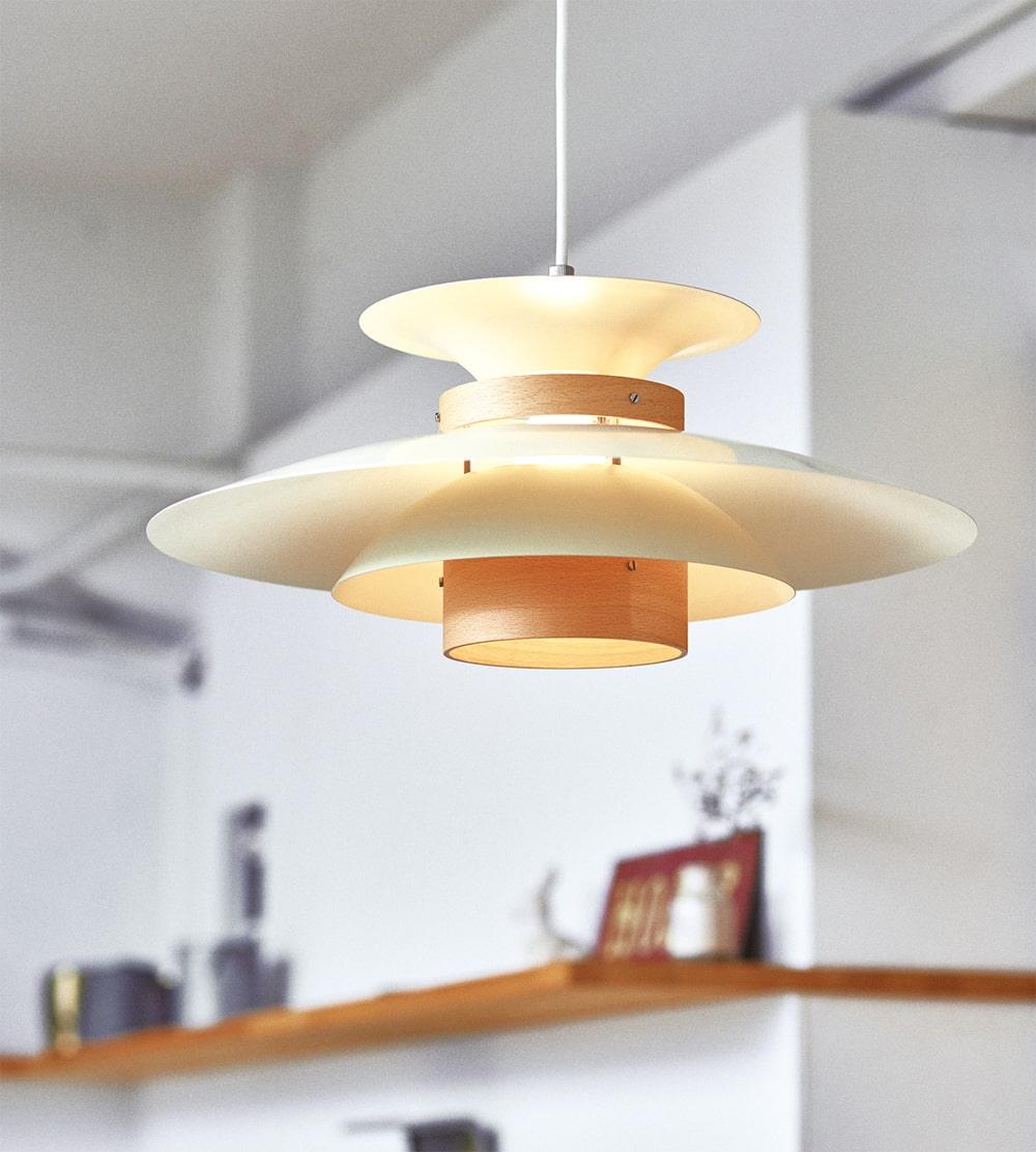 Angled underside view of the lit beige shades and walnut ring on this Clérachic pendant.