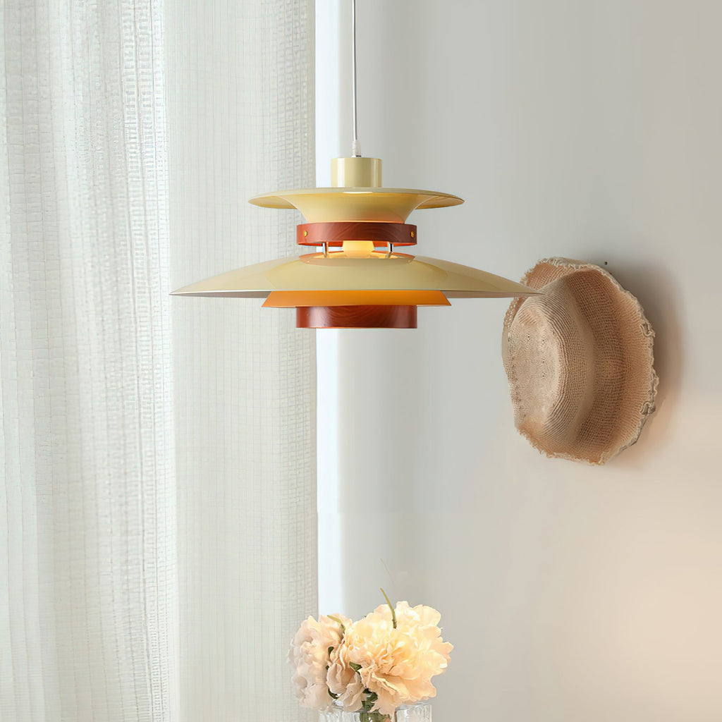 Close view of the beige tiered shades on this Clérachic pendant against a sheer curtain.