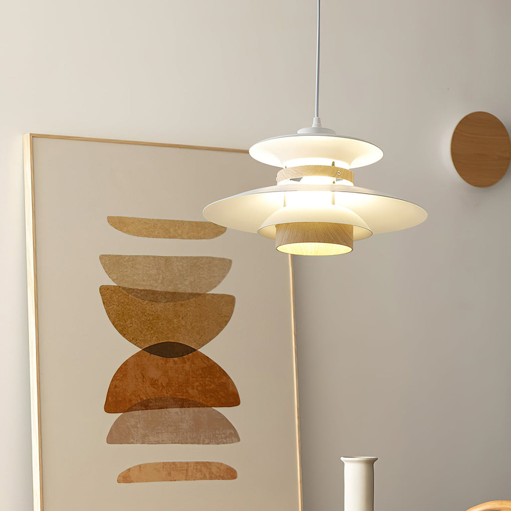 A white Clérachic pendant hangs beside a framed abstract print on a plain wall.