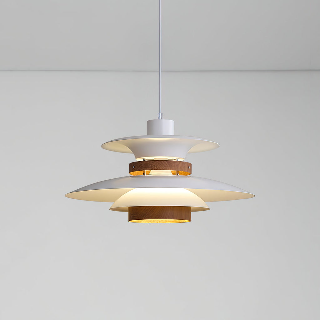 A lit white Clérachic pendant glows warmly against a plain grey wall and ceiling.