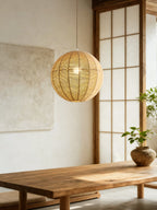 A sliding panel door and long wood table sit in a dining area lit by this hemp rope Clérachic pendant.