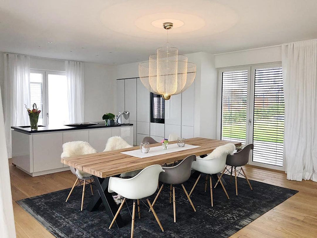 Spherical wire pendant light lit above a seating area