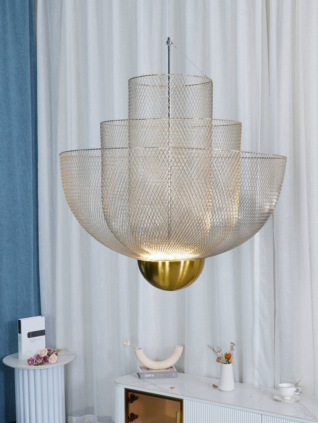 Spherical steel wire pendant light glowing over a dining table