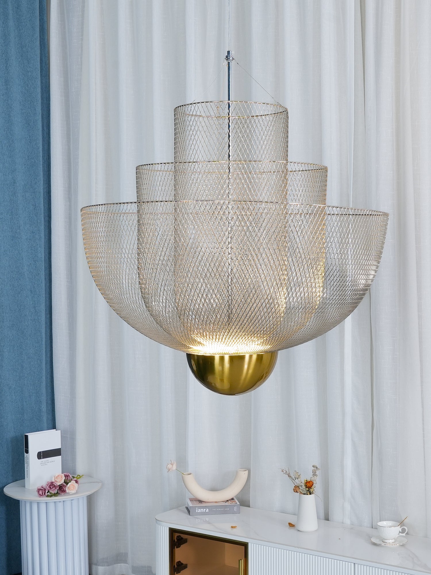 Spherical steel wire pendant light glowing over a dining table