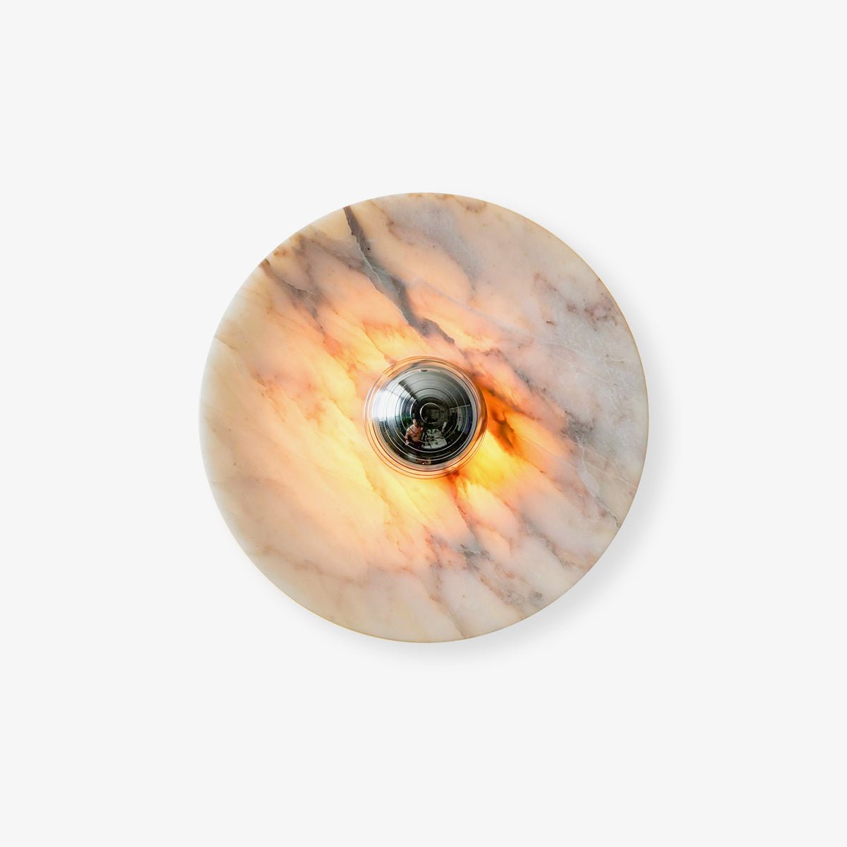 Clérachic marble disc wall light photographed on a plain white studio backdrop, lit warm amber around its chrome touch-control centre.