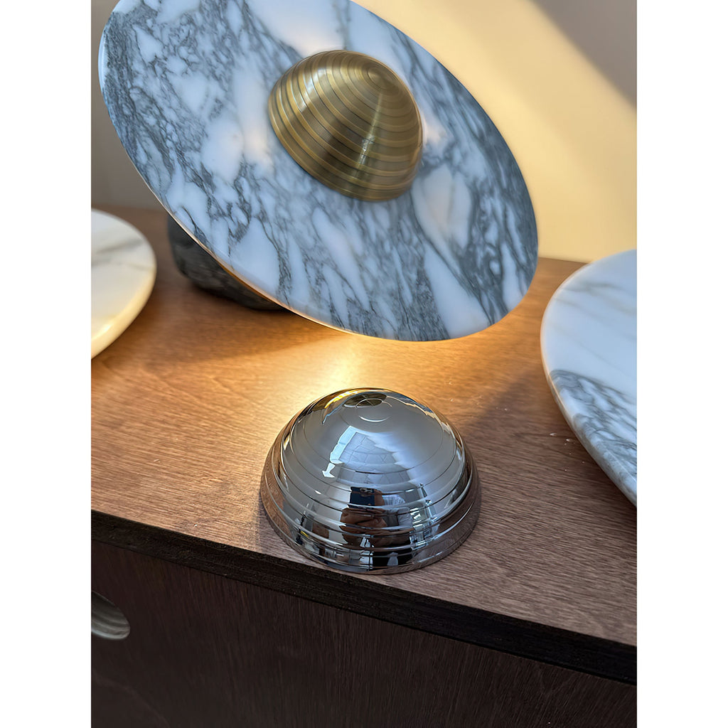 A closer, lower-angle crop of the dresser scene frames the Clérachic disc's brass dome centre beside a chrome dome and second disc.
