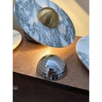 A closer, lower-angle crop of the dresser scene frames the Clérachic disc's brass dome centre beside a chrome dome and second disc.