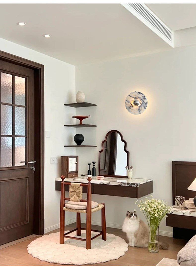 The widest version of this entryway scene shows the glowing Clérachic wall light beneath a vented ceiling, with the cat and mirror below.