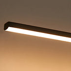Slim bar wall light glowing softly beside a mirror