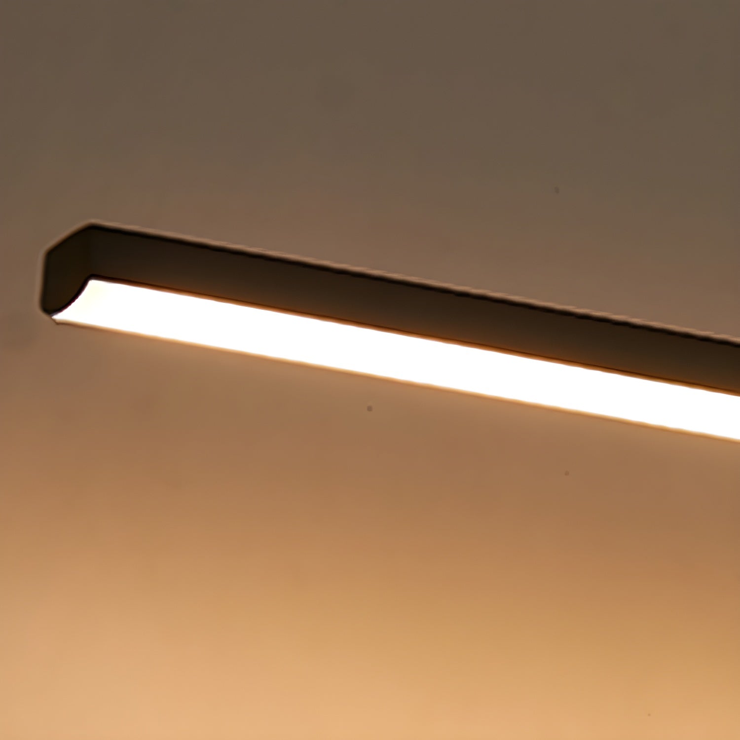 Slim bar wall light glowing softly beside a mirror