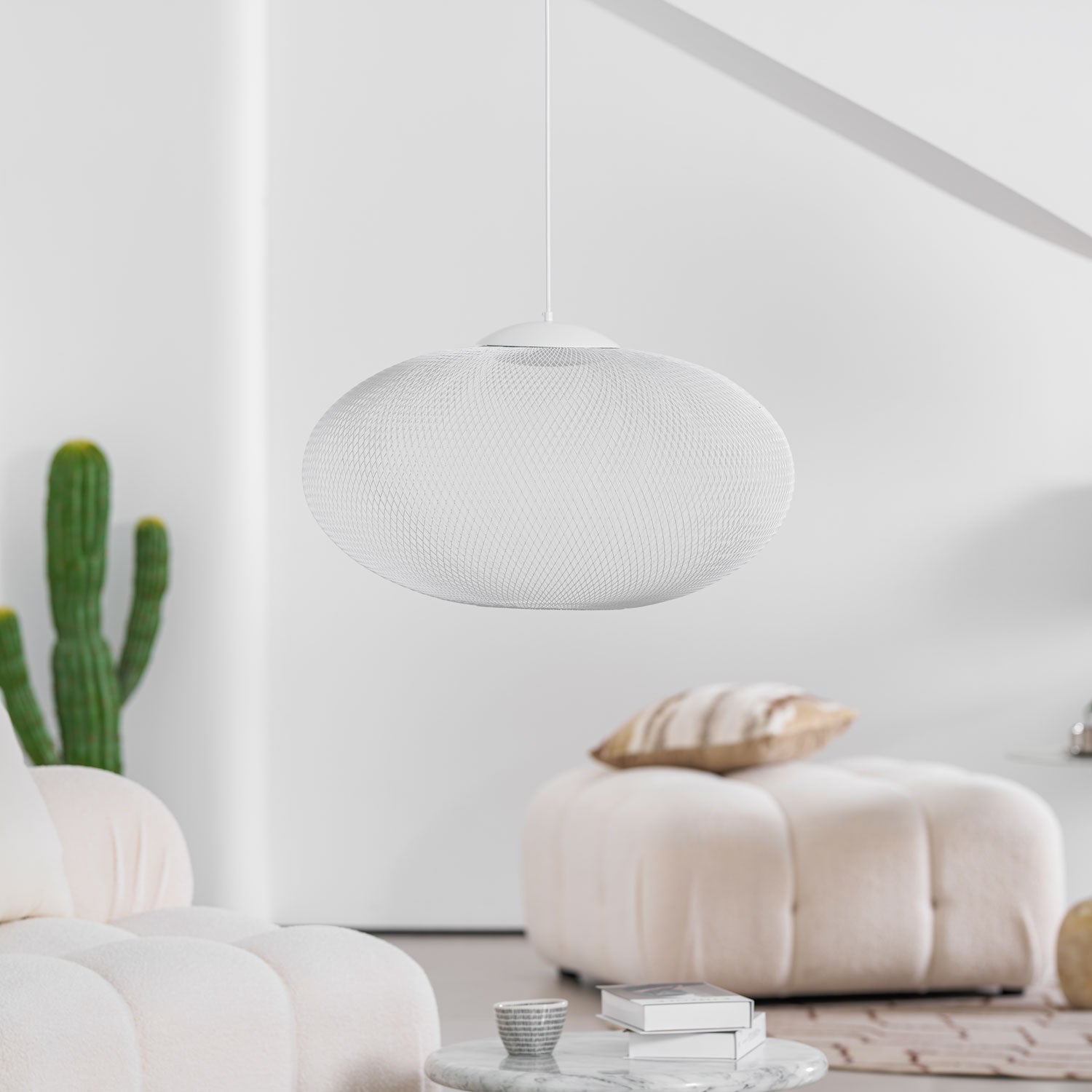 Black mesh pendant light shown lit at a bedside