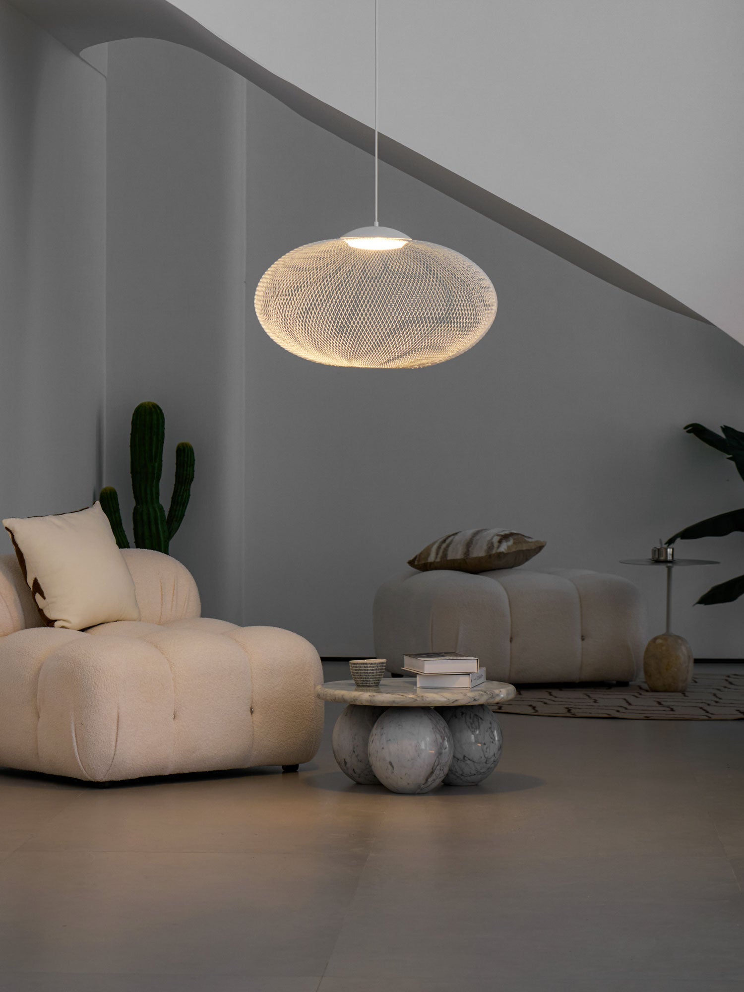 Latticed pendant light shown lit in a styled room