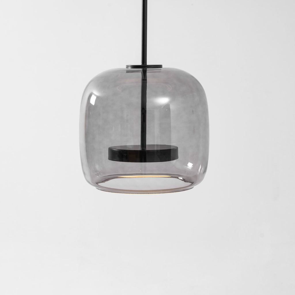 Hand-blown glass pendant light suspended over a table