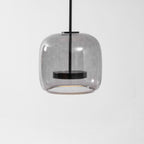 Hand-blown glass pendant light suspended over a table