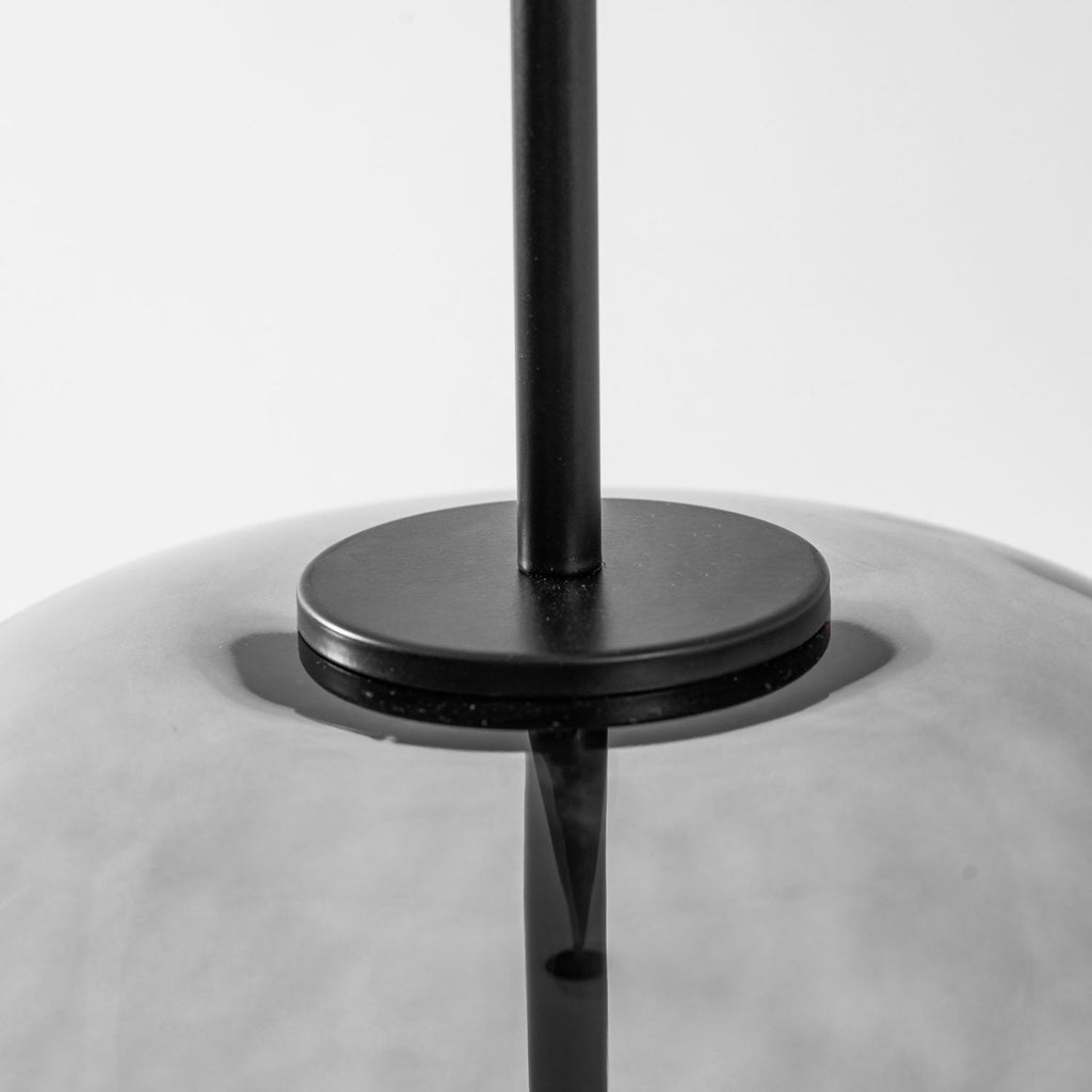 Smoked glass pendant light glowing in a modern living space