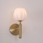 Brass Eurzorion wall light front-on against a soft pink-grey wall, its fluted shade unlit