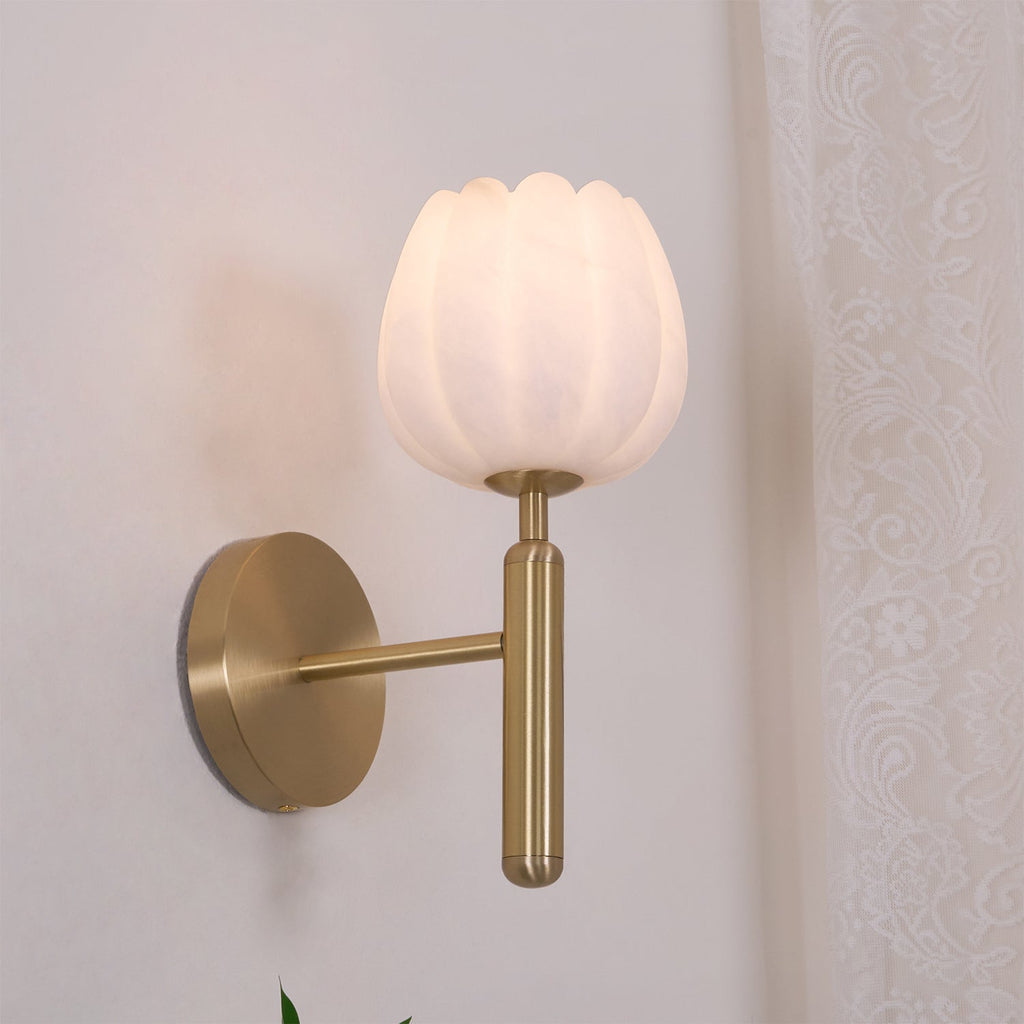 The brass Eurzorion wall light switched on beside a sheer curtain, shade glowing a soft warm white