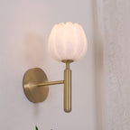 The brass Eurzorion wall light switched on beside a sheer curtain, shade glowing a soft warm white