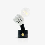 Set against plain grey, this Clérachic novelty table lamp's clear bulb sits only faintly lit above its black marble base.