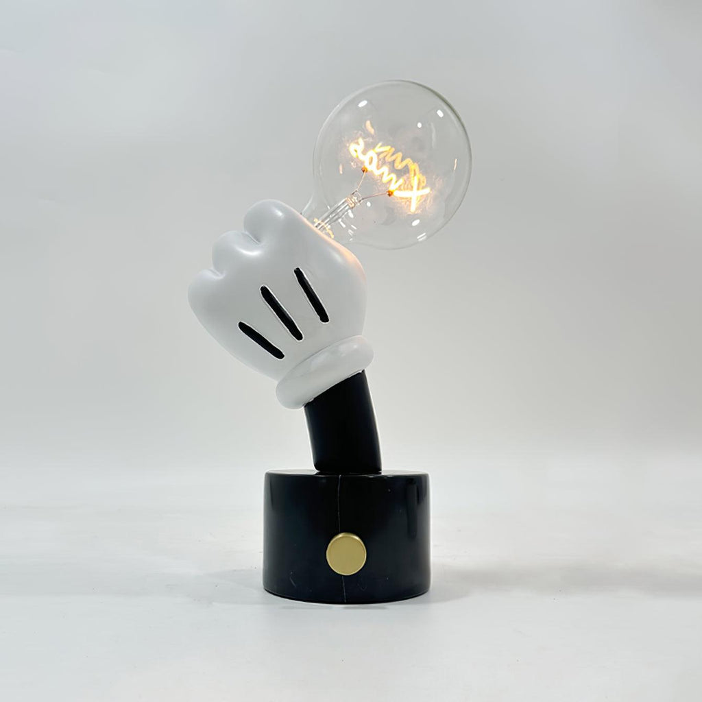 Warm light glows from the cognac-tinted bulb on this Clérachic novelty table lamp, set on black marble against plain grey.